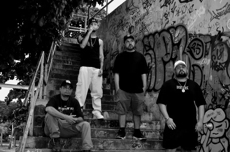 PH1DV, LOBK, Camuri e Felipe Pipo, do grupo de rap 1DV, numa escadaria grafitada na Ilha do Governador, Rio de Janeiro